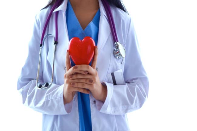 רופאה מחזיקה לב ומסמלת טיפול במחלות לב בנשים